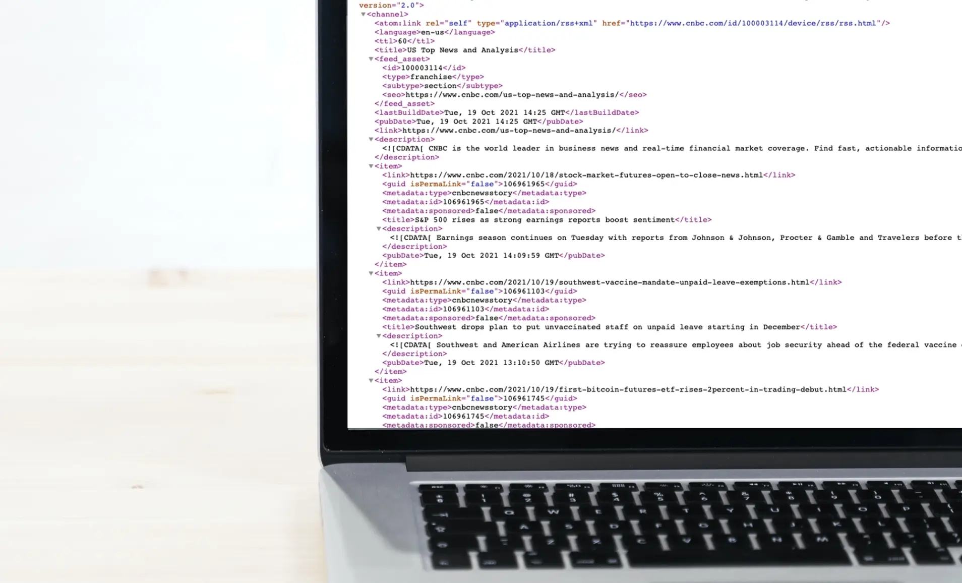 A laptop screen showing the .XML file of an RSS feed URL